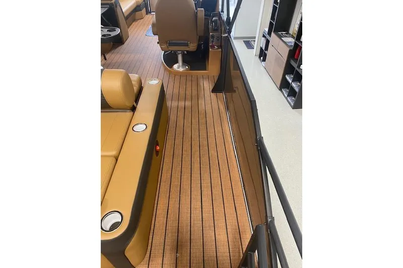 Slide: The Image of 2026 Bentley Pontoons Elite 253 Swingback interior with tan seating and wood-style flooring. - 19