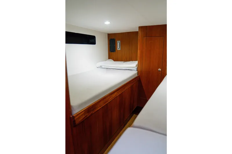 Slide: The Image of 2026 Front Runner 47 W/A cabin interior with wooden finish and cozy bedding. - 12