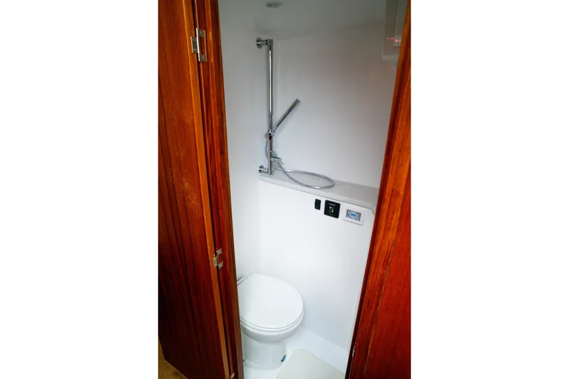 Slide: The Image of Compact bathroom in 2026 Front Runner 47 W/A boat with wooden door and modern fixtures. - 13