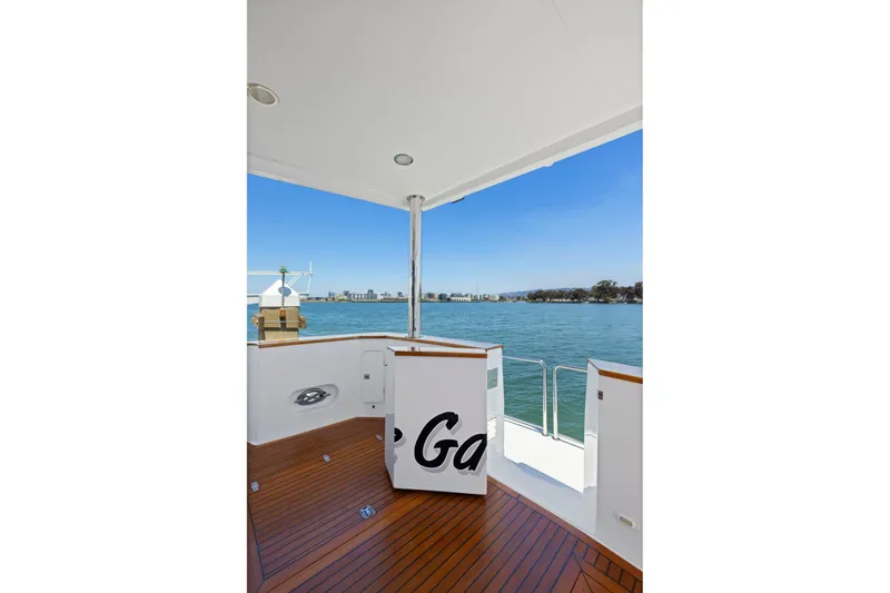 Slide: The Image of Deck view from a 1999 Symbol 558 yacht overlooking calm waters and distant cityscape. - 12