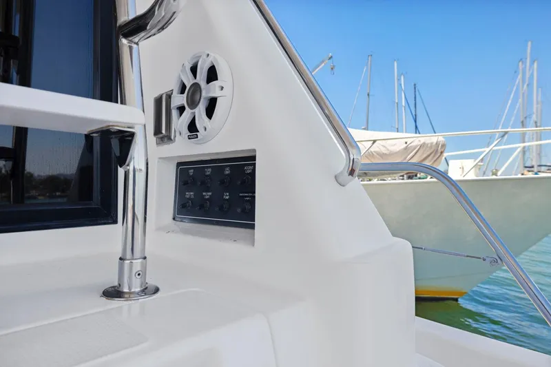 Slide: The Image of Control panel and speaker on a 1999 Symbol 558 yacht, docked with sailboats in background. - 14