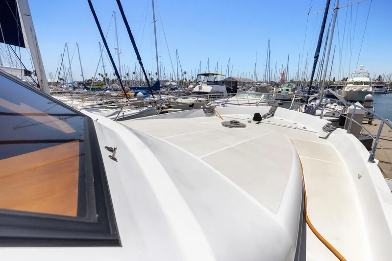 Slide: The Image of Deck view of a 1999 Symbol 558 yacht docked in a marina with sailboats. - 17