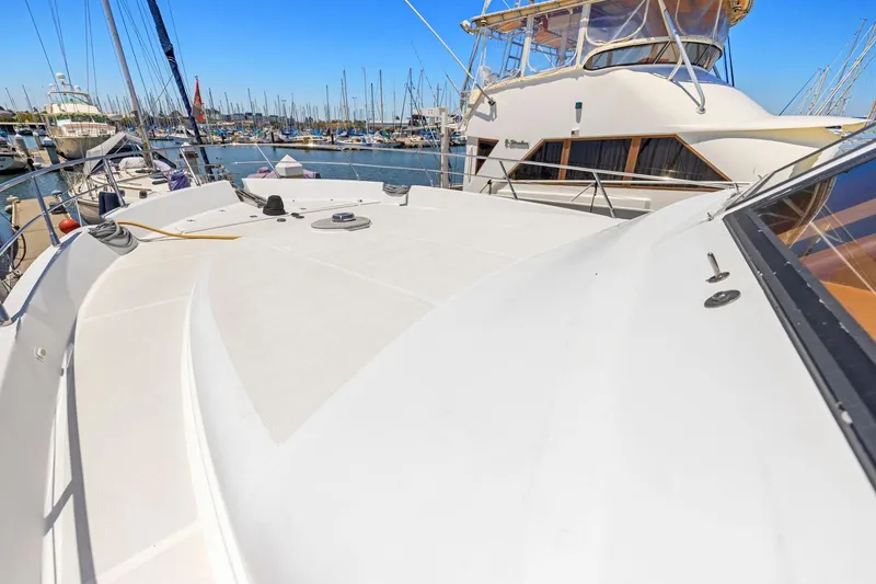 Slide: The Image of Luxury yacht deck at marina, Symbol 558 model, 1999, with clear blue sky. - 18