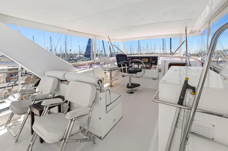 Slide: The Image of Spacious helm of 1999 Symbol 558 yacht with white seating and marina view. - 21