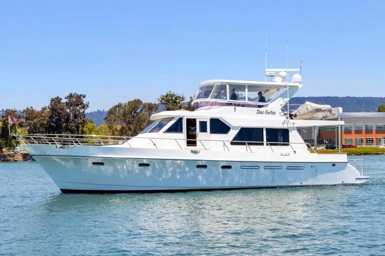 Slide: The Image of White 1999 Symbol 558 yacht cruising on a sunny day near a shoreline. - 3