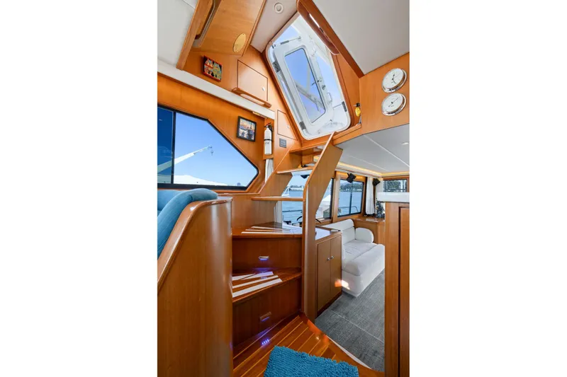 Slide: The Image of Interior of a 1999 Symbol 558 yacht with wooden stairs and seating area. - 33