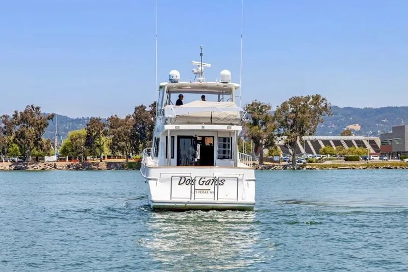 Slide: The Image of A 1999 Symbol 558 yacht cruising on a scenic waterway with trees and buildings in the background. - 4