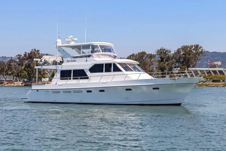 Slide: The Image of White 1999 Symbol 558 yacht cruising on a calm waterway with trees in the background. - 5