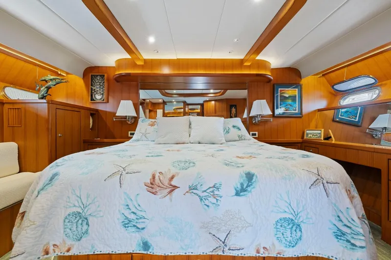Slide: The Image of Luxurious yacht bedroom with nautical-themed bedding, warm wood paneling, and elegant decor. - 50