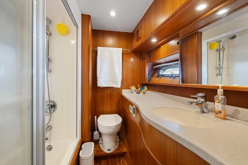 Slide: The Image of Luxurious yacht bathroom with wooden accents, featuring a shower, toilet, and sink. Symbol 558, 1999. - 53