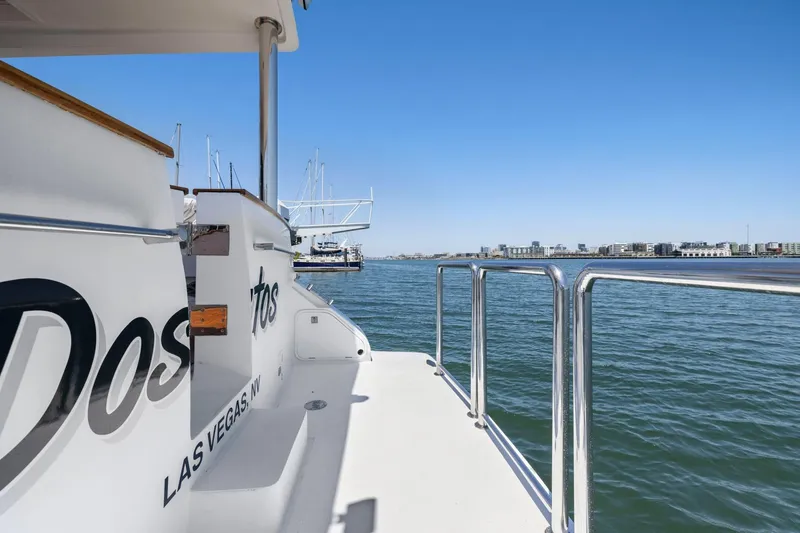 Slide: The Image of Side view of a 1999 Symbol 558 yacht docked in a marina with cityscape background. - 6