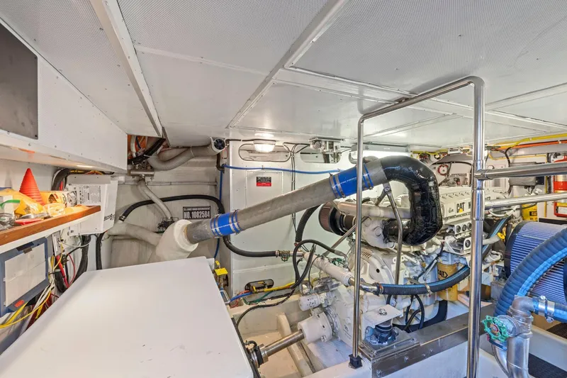 Slide: The Image of Engine room of a 1999 Symbol 558 yacht, featuring complex machinery and piping. - 60