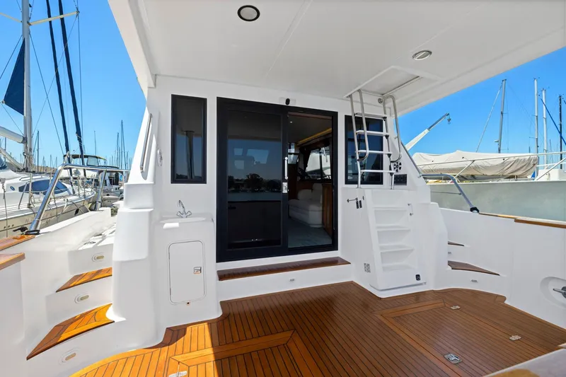 Slide: The Image of Luxury yacht deck with wooden flooring, featuring stairs and a sliding glass door, Symbol 558, 1999. - 9