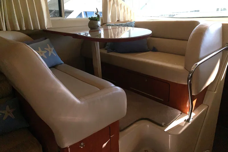 Slide: The Image of Interior of 2000 Sea Ray 400 Sedan Bridge with cozy seating and starfish pillows. - 11