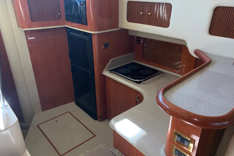 Slide: The Image of Interior of 2000 Sea Ray 400 Sedan Bridge yacht kitchen with stove and cabinetry. - 12