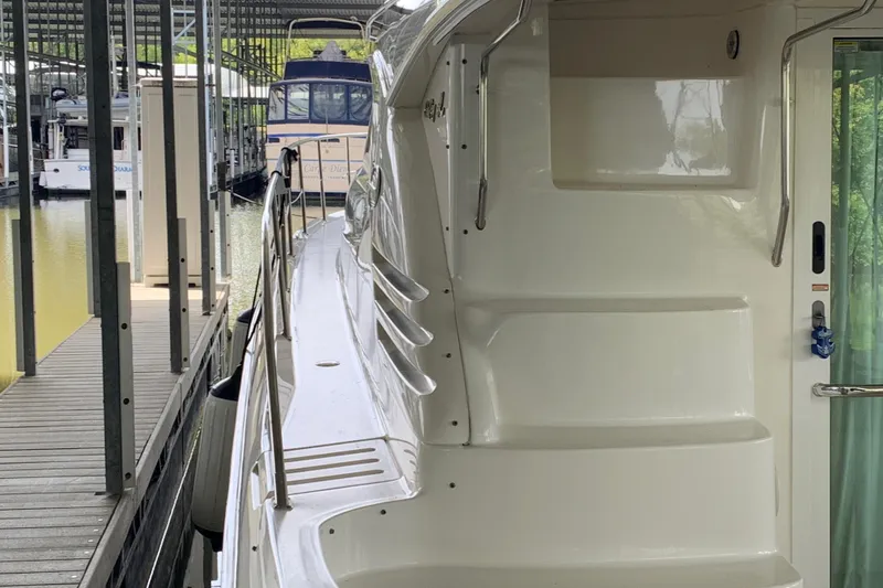 Slide: The Image of 2000 Sea Ray 400 Sedan Bridge yacht docked in a marina, side view. - 4