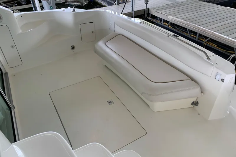 Slide: The Image of 2000 Sea Ray 400 Sedan Bridge boat deck with white seating and storage. - 5