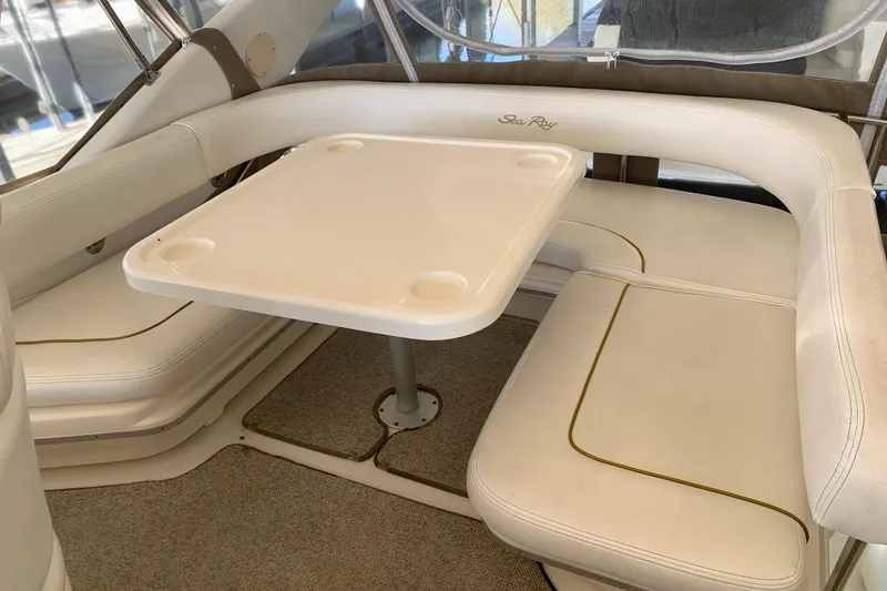 Slide: The Image of 2000 Sea Ray 400 Sedan Bridge interior with white seating and table. - 8