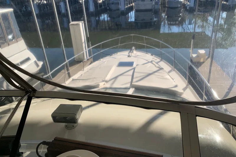 Slide: The Image of View from the helm of a 2000 Sea Ray 400 Sedan Bridge docked at a marina. - 9