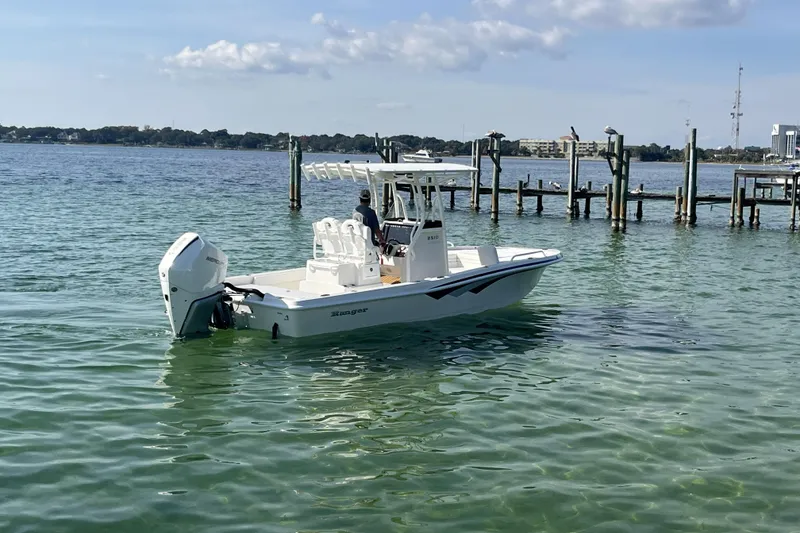 Slide: The Image of 2026 Ranger 2510 Bay boat cruising in a marina with docks and clear water. - 21