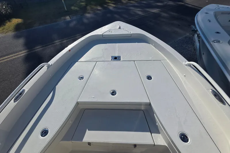 Slide: The Image of 2026 Ranger 2510 Bay boat with Mercury engine, parked outdoors under clear sky. - 5