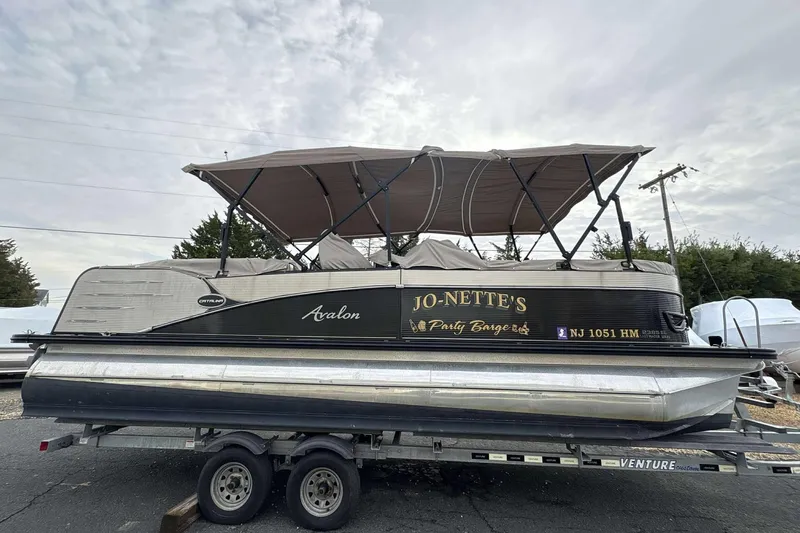 The Image of 2018 Avalon 2385 EL pontoon boat on trailer, labeled "Jo-Nette's Party Barge." - 0