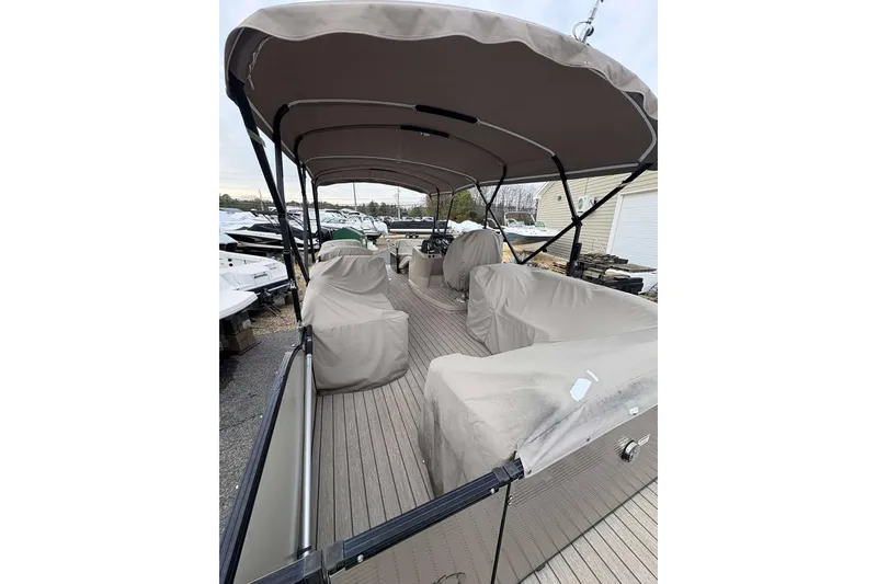 Slide: The Image of 2018 Avalon 2385 EL pontoon boat with covered seating and canopy, docked outdoors. - 10