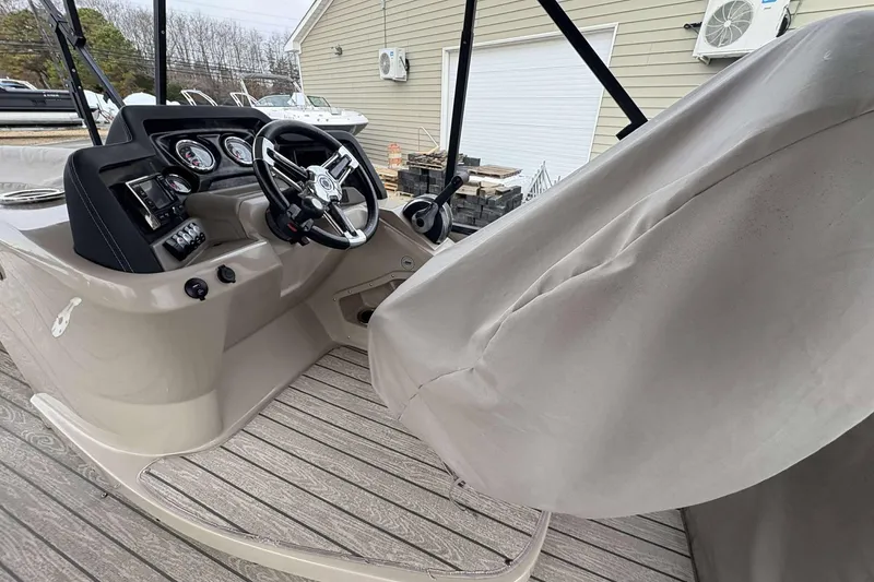Slide: The Image of 2018 Avalon 2385 EL boat cockpit with steering wheel and covered seating. - 12
