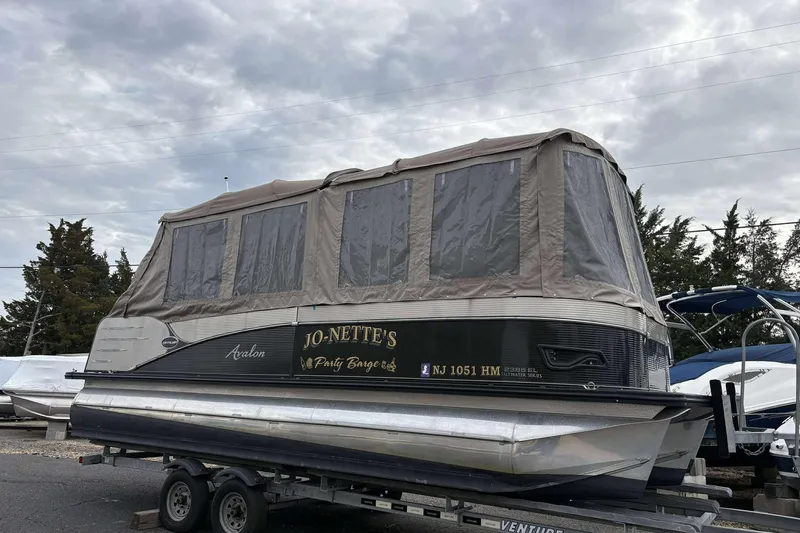 Slide: The Image of 2018 Avalon 2385 EL pontoon boat with canopy on trailer, overcast sky. - 27