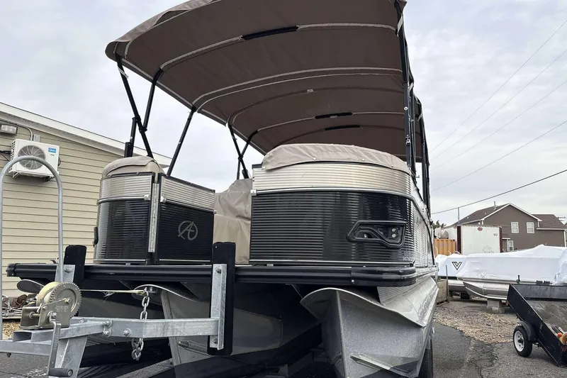 Slide: The Image of 2018 Avalon 2385 EL pontoon boat with canopy on trailer, parked outdoors. - 5
