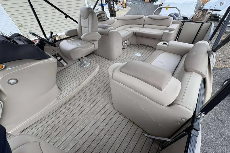 Slide: The Image of 2018 Avalon 2385 EL pontoon boat interior with beige seating and helm. - 8