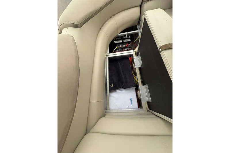 Slide: The Image of 2018 Avalon 2385 EL boat seat storage compartment with open lid, revealing interior contents. - 9
