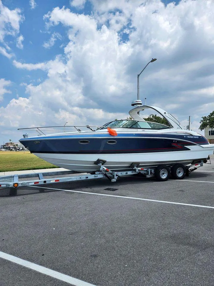 Slide: The Image of 2018 Formula 310 Sun Sport boat on a trailer under a partly cloudy sky. - 6