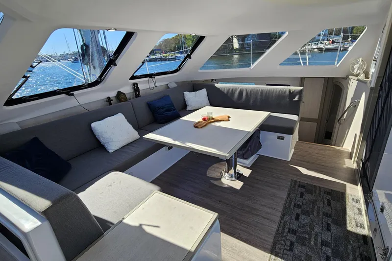 Slide: The Image of Interior of 2022 Seawind 1160 Lite catamaran with spacious seating and large windows. - 5