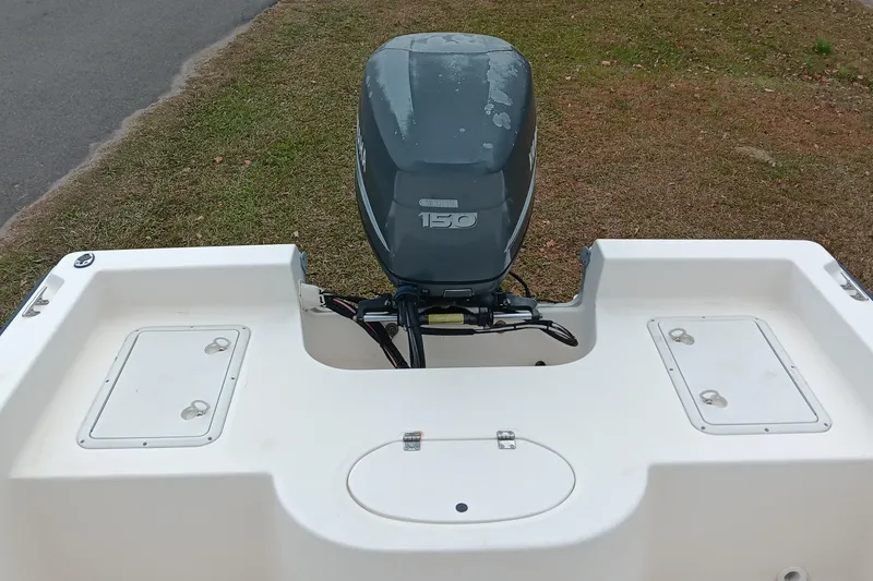 Slide: The Image of 2002 Sea Hunt Navigator 22 boat with a 150 horsepower outboard motor, parked on grass. - 13