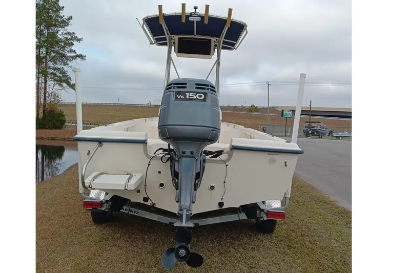 Slide: The Image of 2002 Sea Hunt Navigator 22 boat with V6 150 engine, parked on grass. - 4
