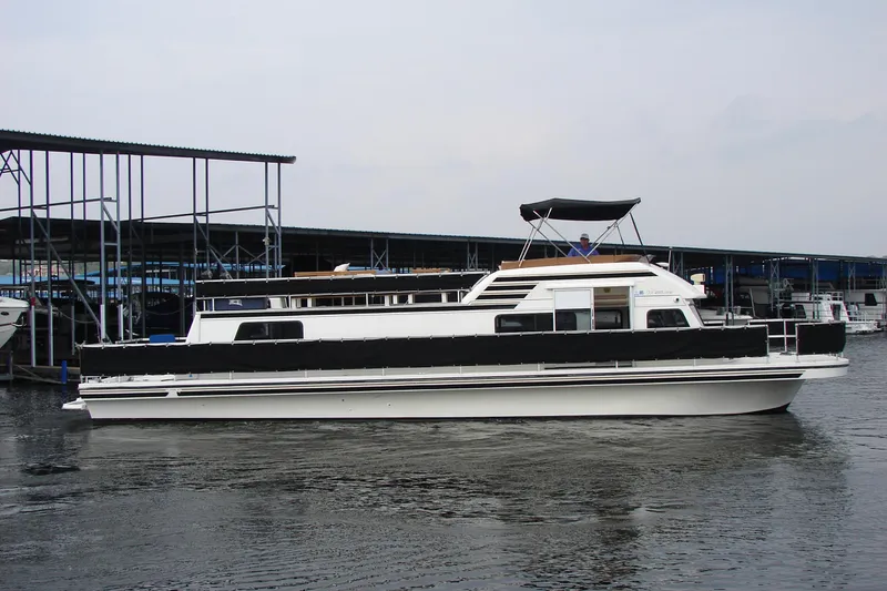 Slide: The Image of 1997 Gibson 47 Sport Houseboat docked at marina, featuring sleek design and spacious deck. - 13