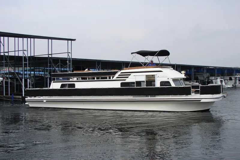 Slide: The Image of 1997 Gibson 47 Sport Houseboat docked at marina, featuring sleek design and spacious deck. - 14