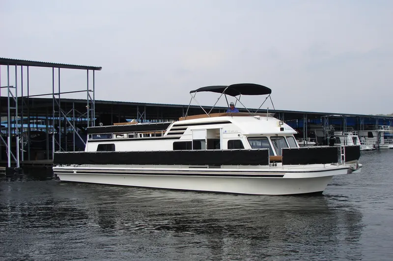 Slide: The Image of 1997 Gibson 47 Sport Houseboat docked at marina, featuring sleek design and spacious deck. - 15