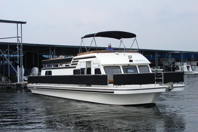 Slide: The Image of 1997 Gibson 47 Sport Houseboat docked at marina, featuring upper deck canopy. - 16