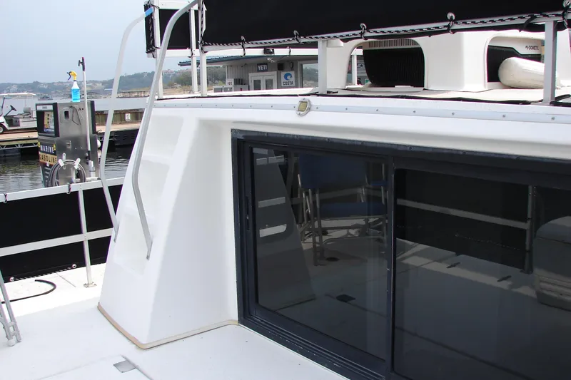 Slide: The Image of 1997 Gibson 47 Sport Houseboat with sleek design and marina backdrop. - 25