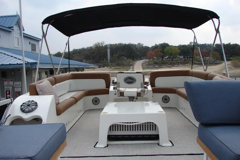 Slide: The Image of 1997 Gibson 47 Sport Houseboat with spacious seating and canopy, docked near a scenic shoreline. - 33
