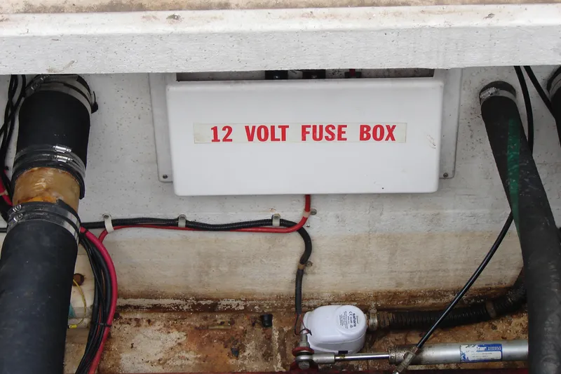 Slide: The Image of 12-volt fuse box on 1997 Gibson 47 Sport Houseboat, surrounded by wiring and hoses. - 37