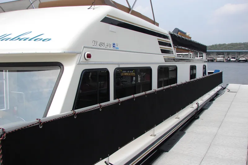 Slide: The Image of 1997 Gibson 47 Sport Houseboat docked at marina, side view. - 39