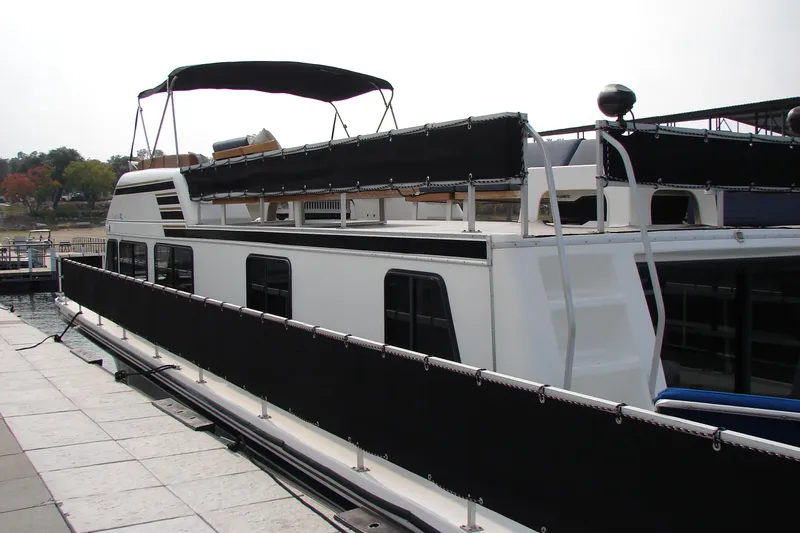 Slide: The Image of 1997 Gibson 47 Sport Houseboat docked at marina, featuring upper deck and canopy. - 42