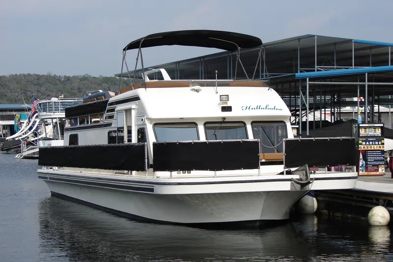 Slide: The Image of 1997 Gibson 47 Sport Houseboat docked at marina, featuring spacious deck and canopy. - 45