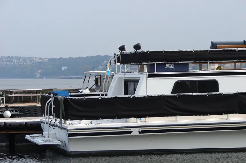 Slide: The Image of 1997 Gibson 47 Sport Houseboat docked by a scenic waterfront. - 51