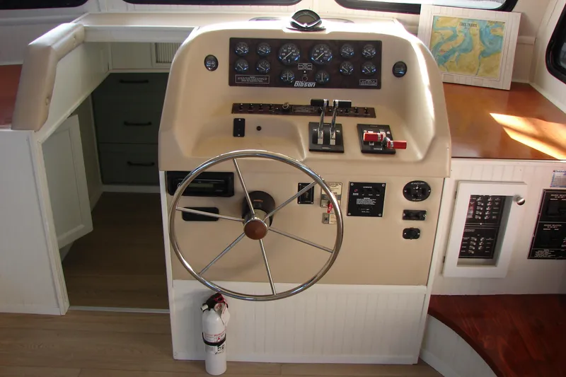 Slide: The Image of 1997 Gibson 47 Sport Houseboat helm with steering wheel and control panel. - 54