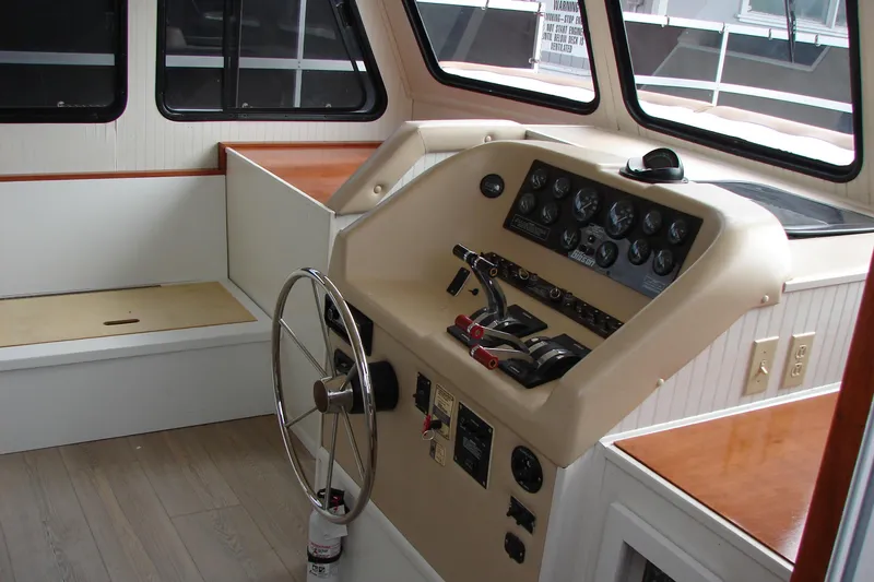 Slide: The Image of 1997 Gibson 47 Sport Houseboat helm with steering wheel and control panel. - 55