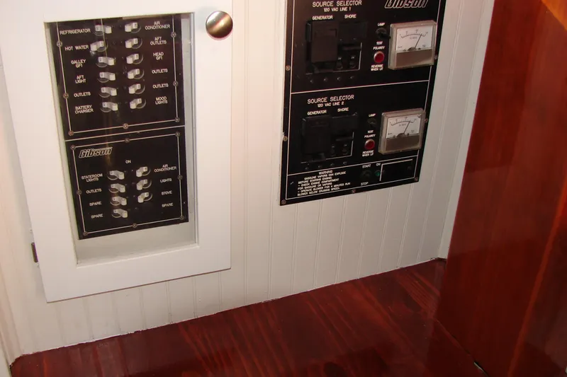 Slide: The Image of Electrical control panel on a 1997 Gibson 47 Sport Houseboat, featuring switches and meters. - 56